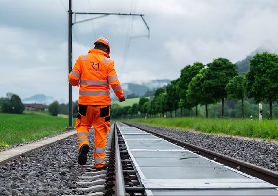 Een baanwerker inspecteert de pv tussen de rals. Foto Credits SNCF + Sun-Ways