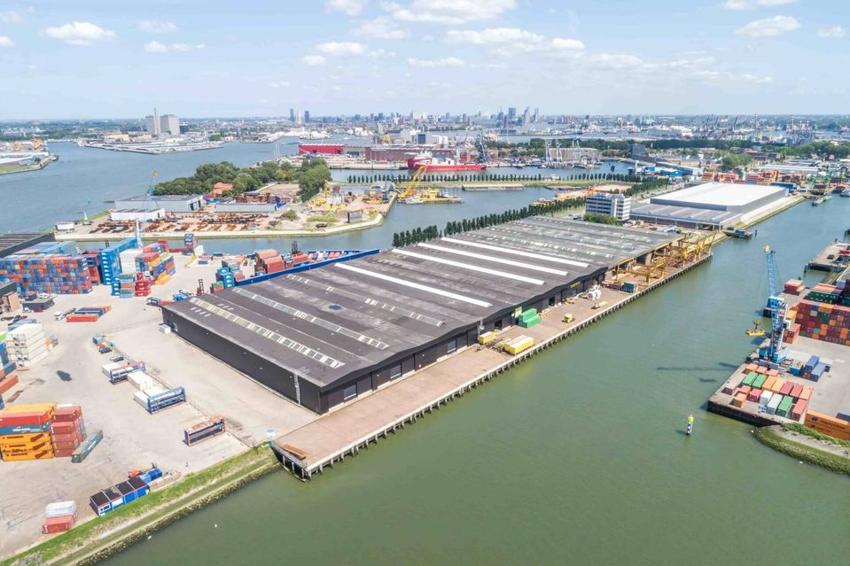Luchtfoto van een grote bedrijfshal met kade in de Rotterdamse Eemhaven.