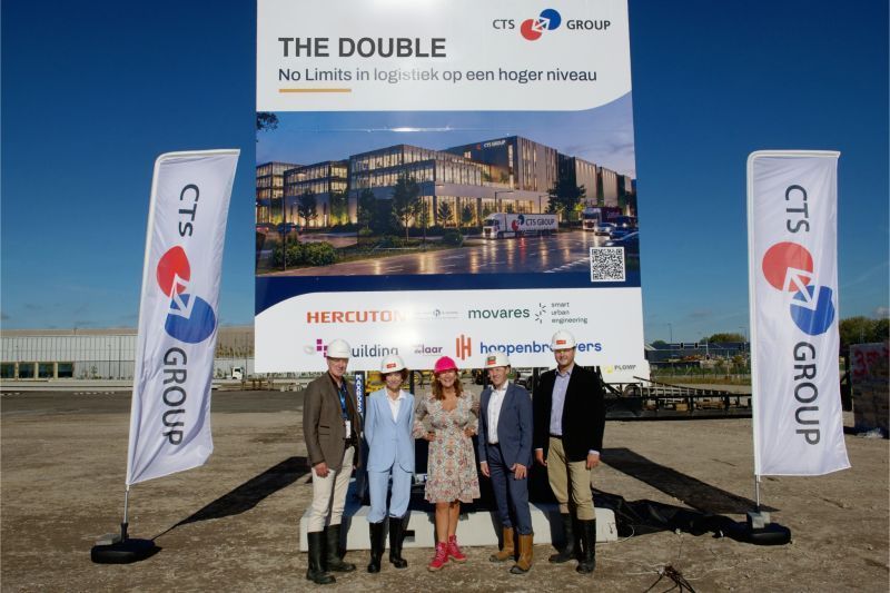 Groep van vijf personen voor bouwbord van The Double op Schiphol Trade Park.