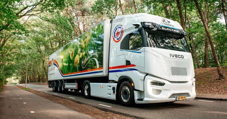 Witte elektrische IVECO S-eWay trekker met oplegger op bosweg.