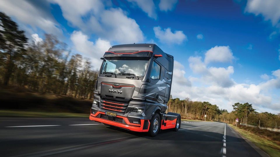 MAN eTGX elektrische trekker rijdend op snelweg met bewolkte lucht.