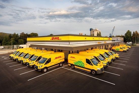 Rij gele DHL-bestelbussen voor nieuw CityHub-gebouw in Eindhoven.
