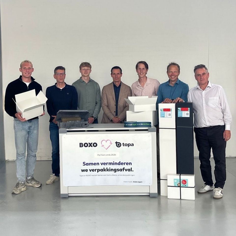 Zeven mensen poseren met herbruikbare dozen en BOXO-inleverpunt.