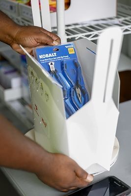 Handen pakken Kobalt-tang uit rek voor drone-bezorging.