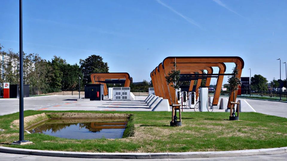 Laadplein voor elektrische trucks met houten overkappingen en laadpalen in Temse.