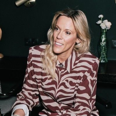 Portret van Eva Faict, glimlachend in een donker interieur.