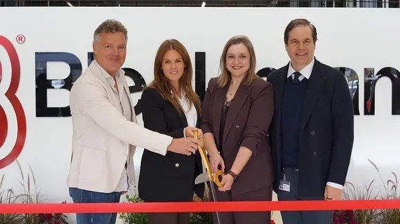 Vier personen knippen rood lint door bij opening Bleckmann-distributiecentrum.