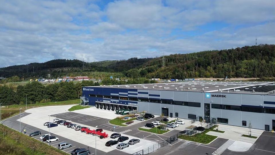 Luchtfoto van Maersk-distributiecentrum in Herleshausen, omgeven door heuvels.
