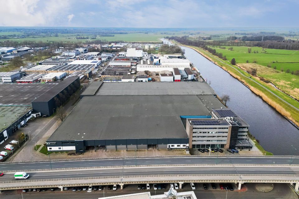 Luchtfoto van groot distributiecentrum aan kanaal op bedrijventerrein Amersfoort.