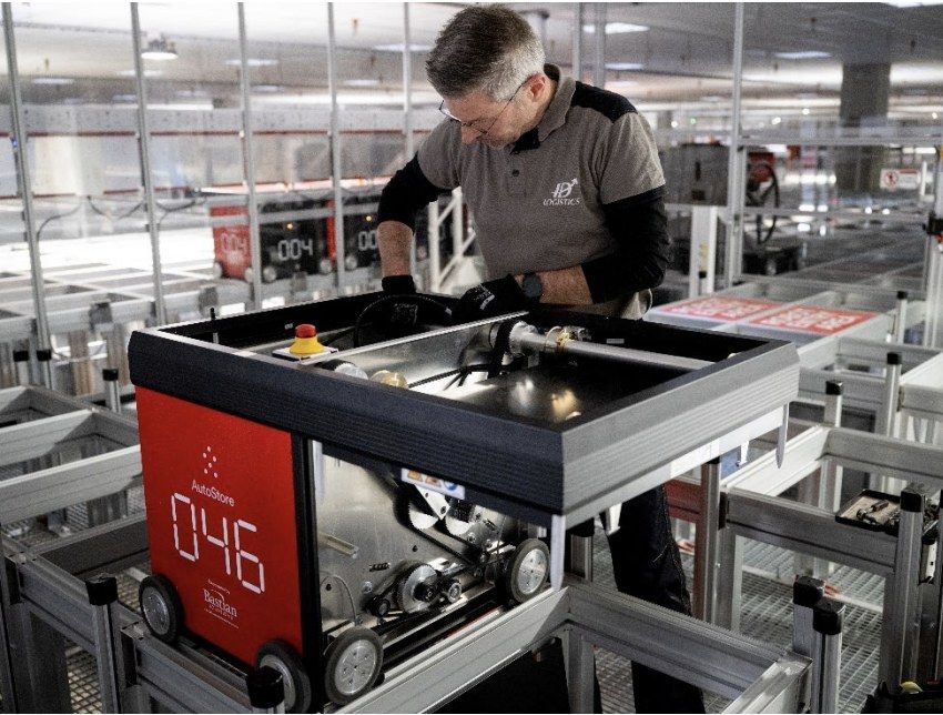 ID Logistics medewerker inspecteert AutoStore-robot nummer 046 op grid.