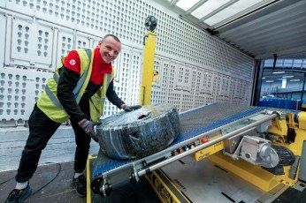 DPD-medewerker gebruikt Destuff-it unit bij containerontlading.
