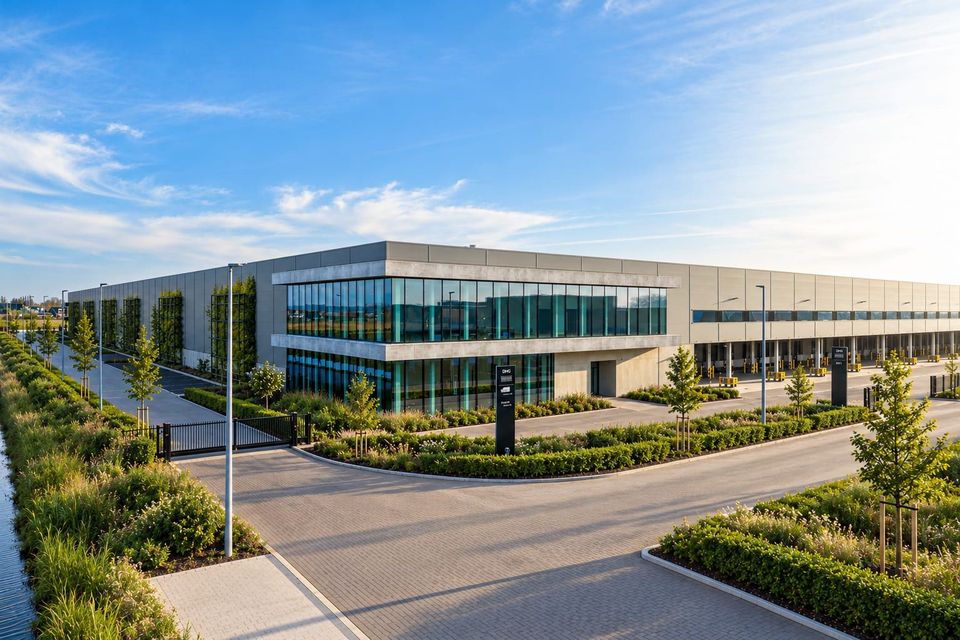 Buitenaanzicht modern distributiecentrum met glazen gevel en groenstroken.