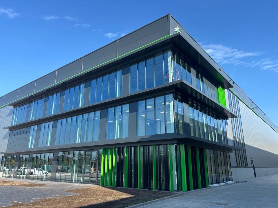 Exterieur nieuw distributiecentrum Venray met glazen gevel en groene accenten.
