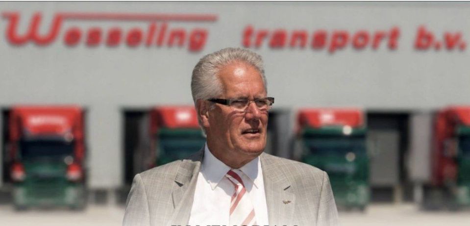 Portret van John Wesseling voor vrachtwagens bij Wesseling Transport.