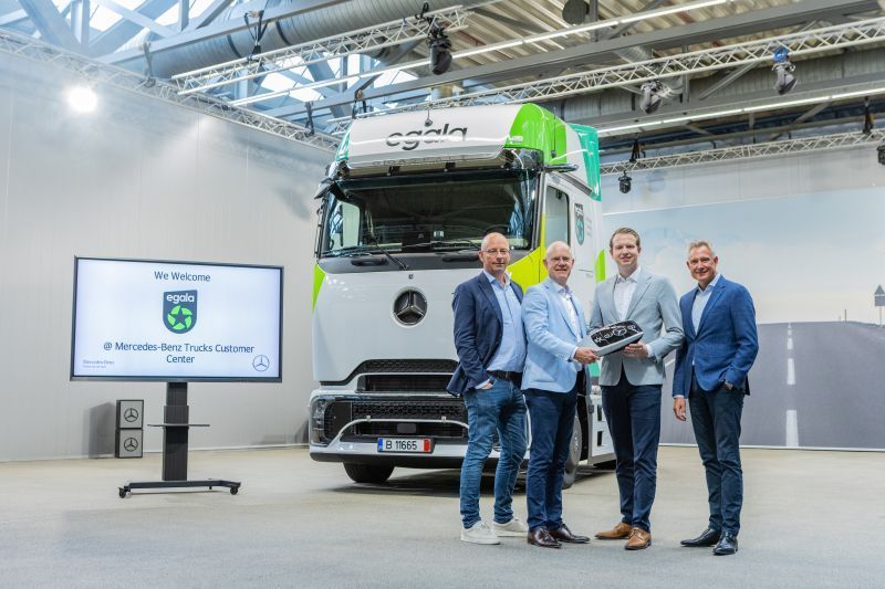 Vier mannen poseren voor een elektrische Mercedes-Benz eActros 600 met Egala-branding.