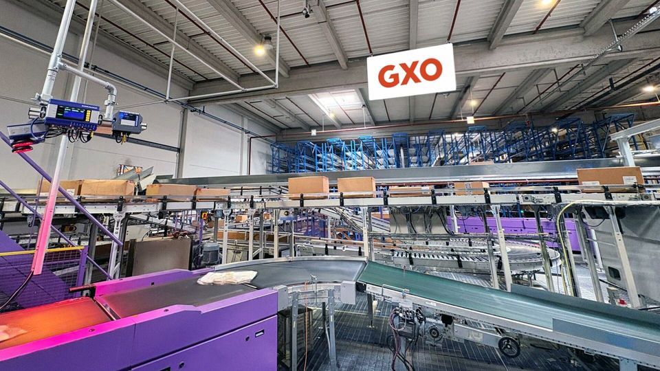 Geautomatiseerde transportbanden en sorteersysteem in GXO-distributiecentrum.