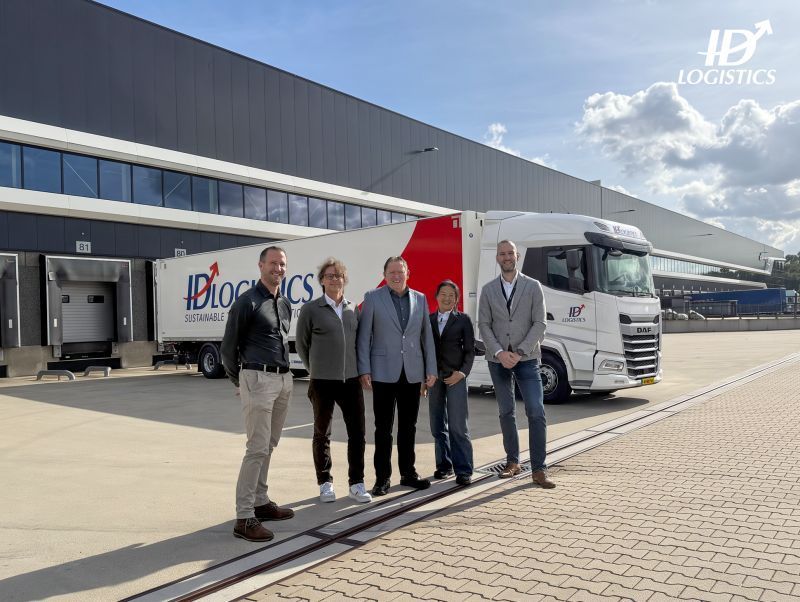 Vijf mensen staan voor een ID Logistics vrachtwagen bij distributiecentrum Tilburg.