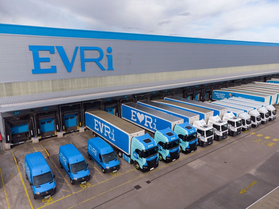 Blauwe Evri vrachtwagens en bestelbussen geparkeerd voor distributiecentrum.